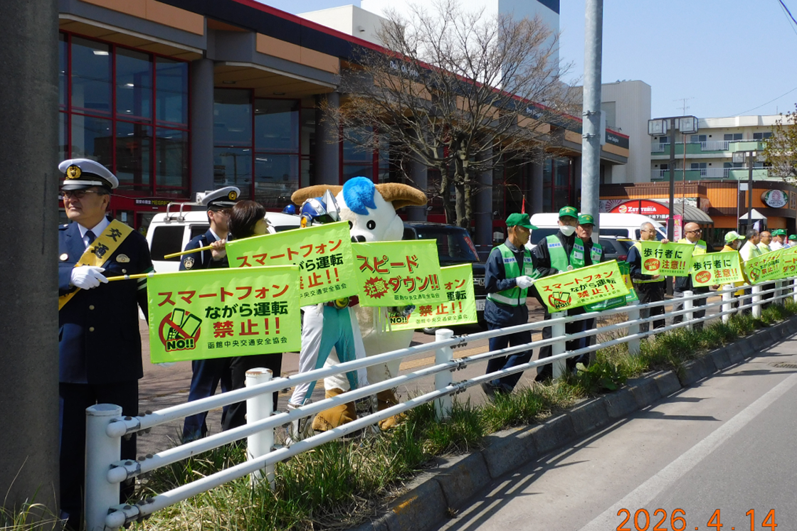 ながら運転をしないように注意する旗を持った函館中央交通安全協会の方々